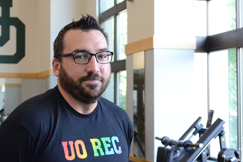Patrick Walker wearing a black T-shirt with the words "UO REC" in rainbow colors