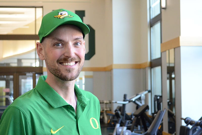 Rich Dana wearing a green UO polo shirt and Ducks baseball hat