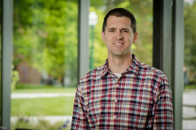 man with short brown hair wearing a plaid shirt