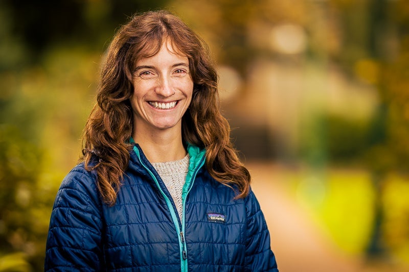 woman with long red hair wearing a puffy blue jacket