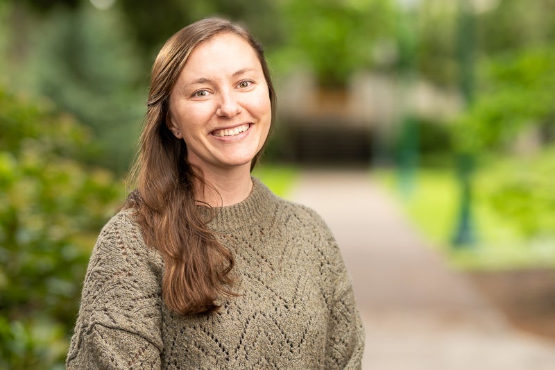 woman with long brown hair wearing a tan sweater