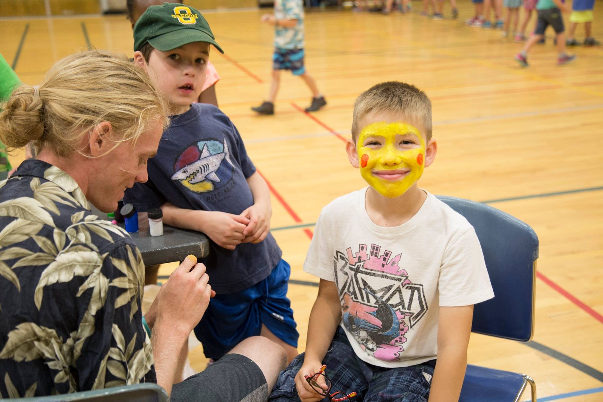 Two children get their faces painted.